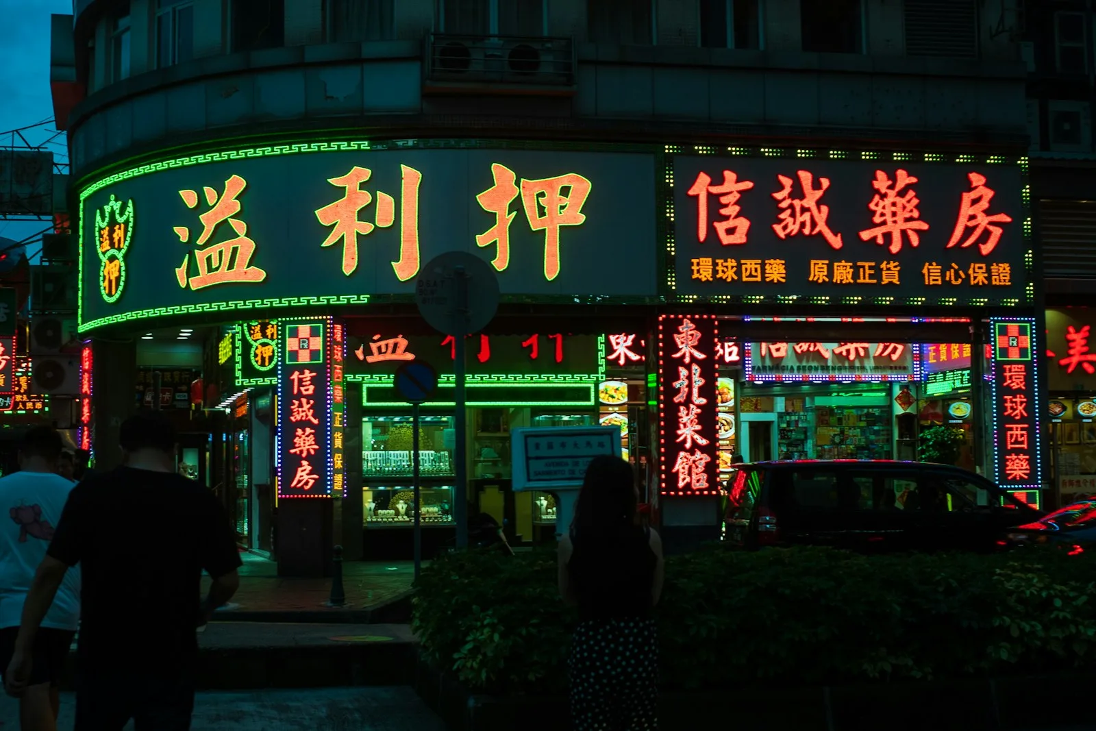 A group of people walking down a street at night